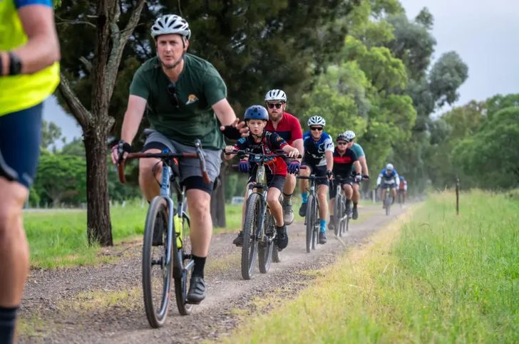 A group of riders on a grassy gravel trail