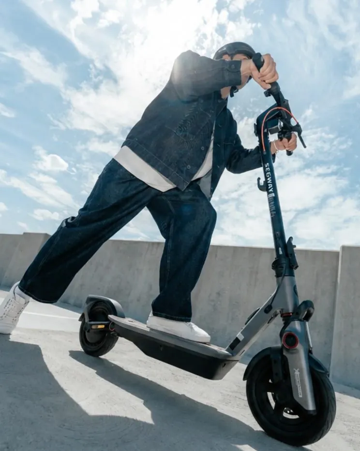 A rider in a helmet on the Segway F3 Pro e-scooter