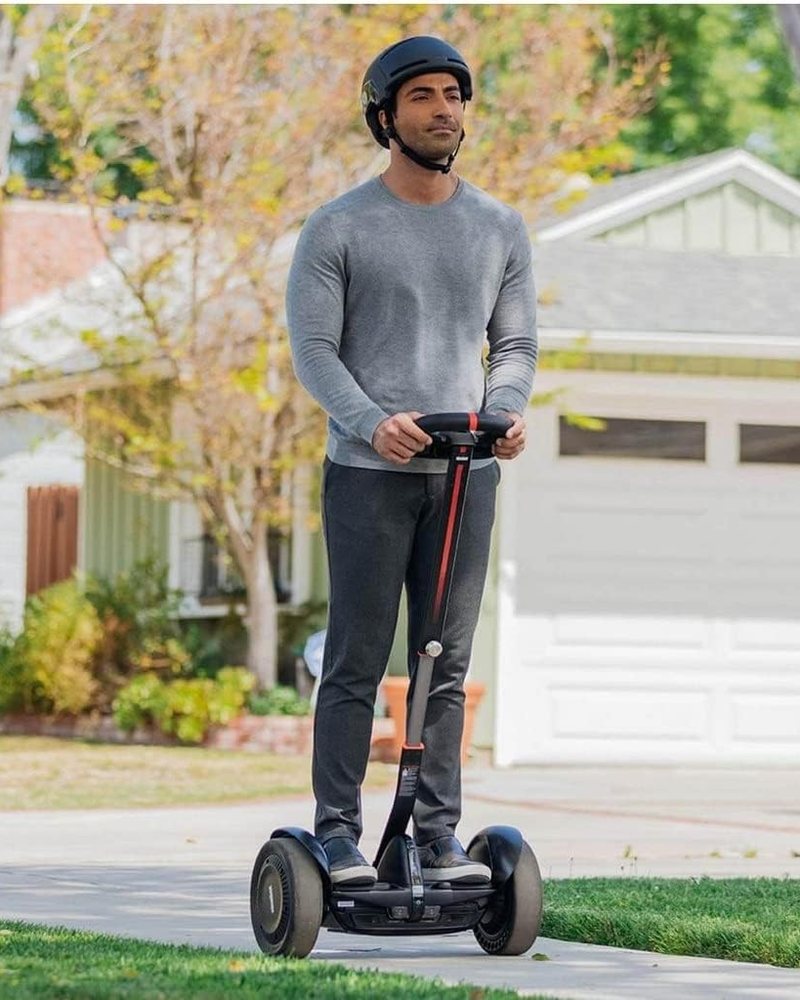 A rider in a helmet on the Segway S-Max self-balancer