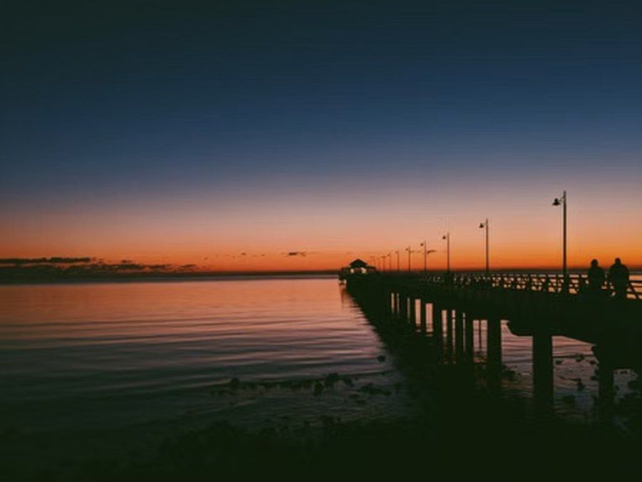 Silhouette eines Stegs in der Bucht bei Dämmerung, typisch für die Uferpromenade von Redcliffe